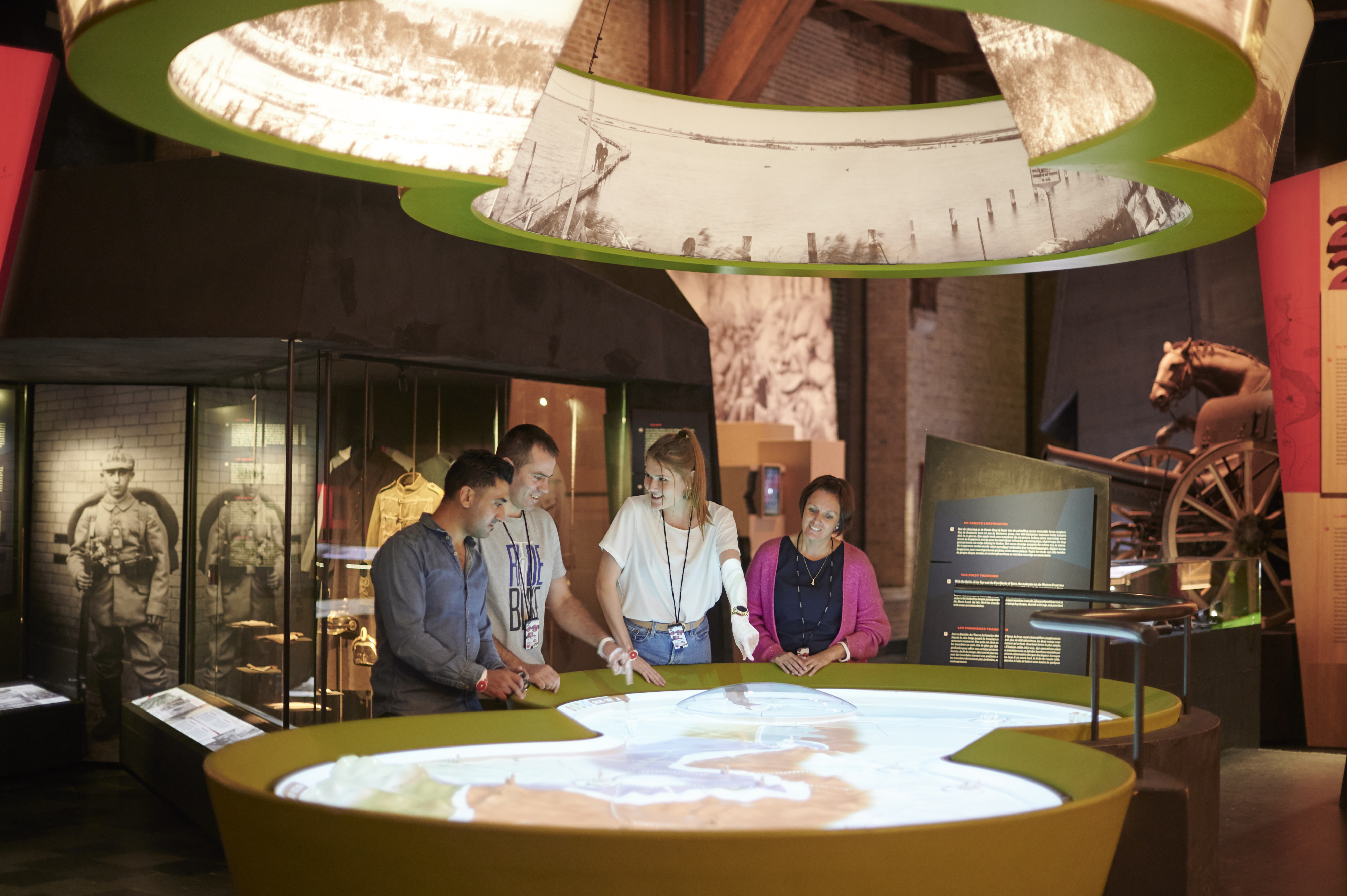 vier mensen die kijken naar een verlichte plattegrond in een museum